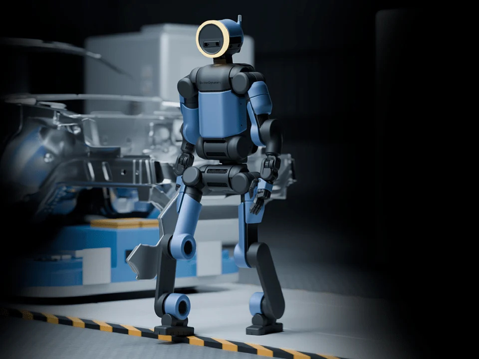 Full-length Atlas humanoid standing beside industrial equipment