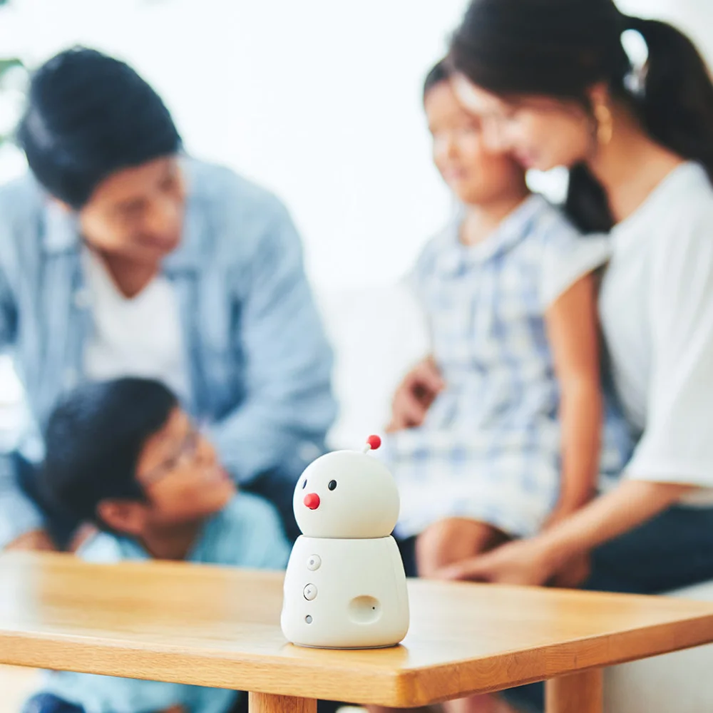 BOCCO emo on a table with a family in the background